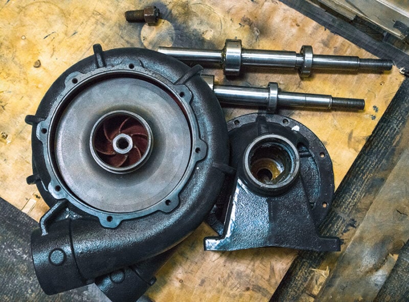 Inner workings of a centrifugal water truck pump laying on a wooden table